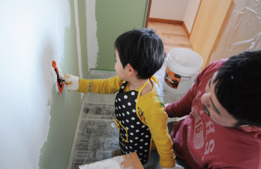 子供が漆喰うまくヌレールを塗っている写真