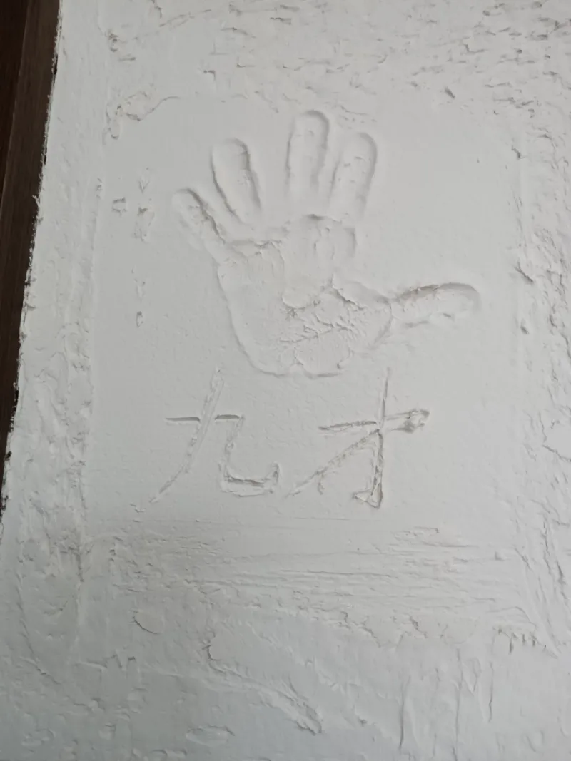 漆喰壁に子供の手形を残した写真